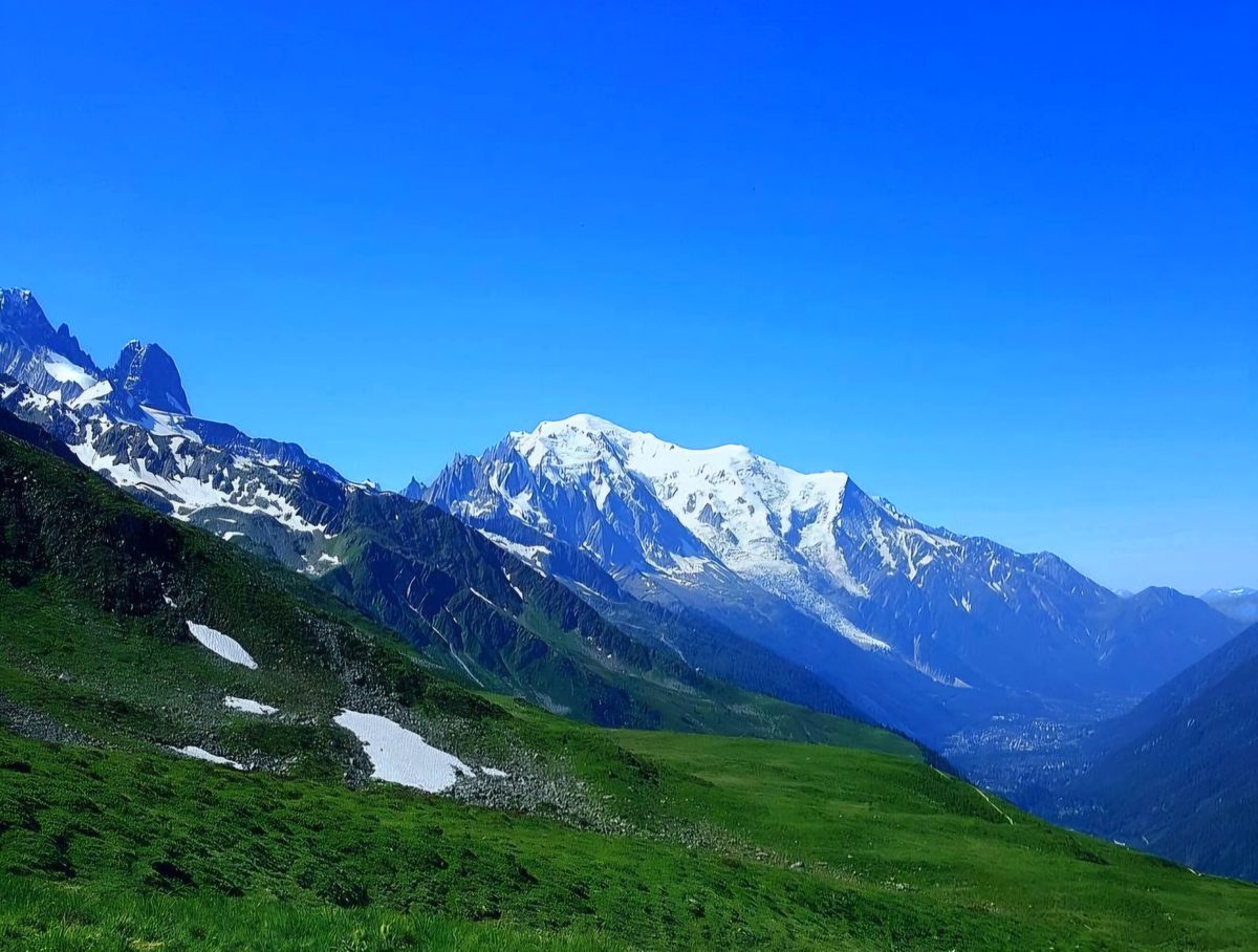 The snow dome of Mont Blanc and the Aiguilles above the Chamonix valley, from the green slopes on the far side of the circuit.