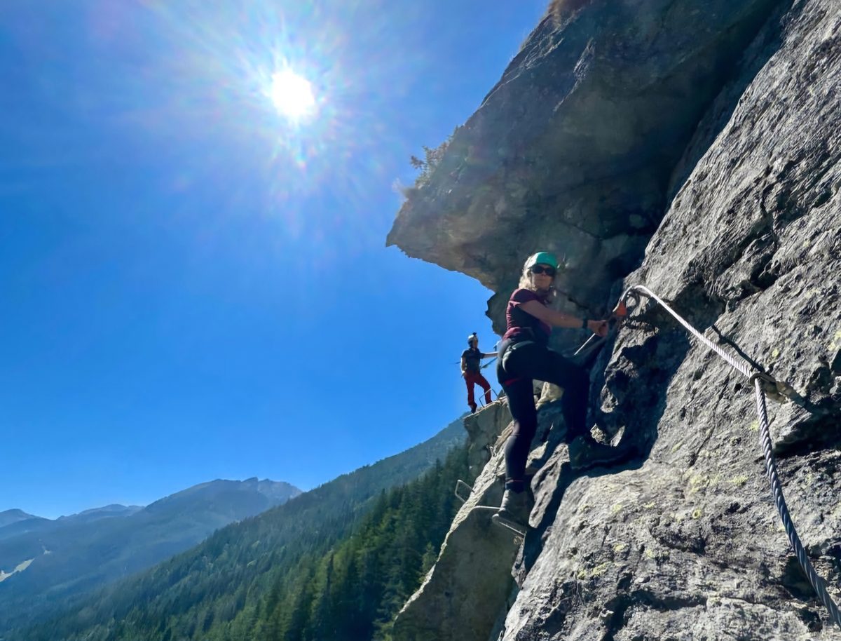 A cabled section of via ferrata, with the steel rope and a rung bolted across steep rock.
